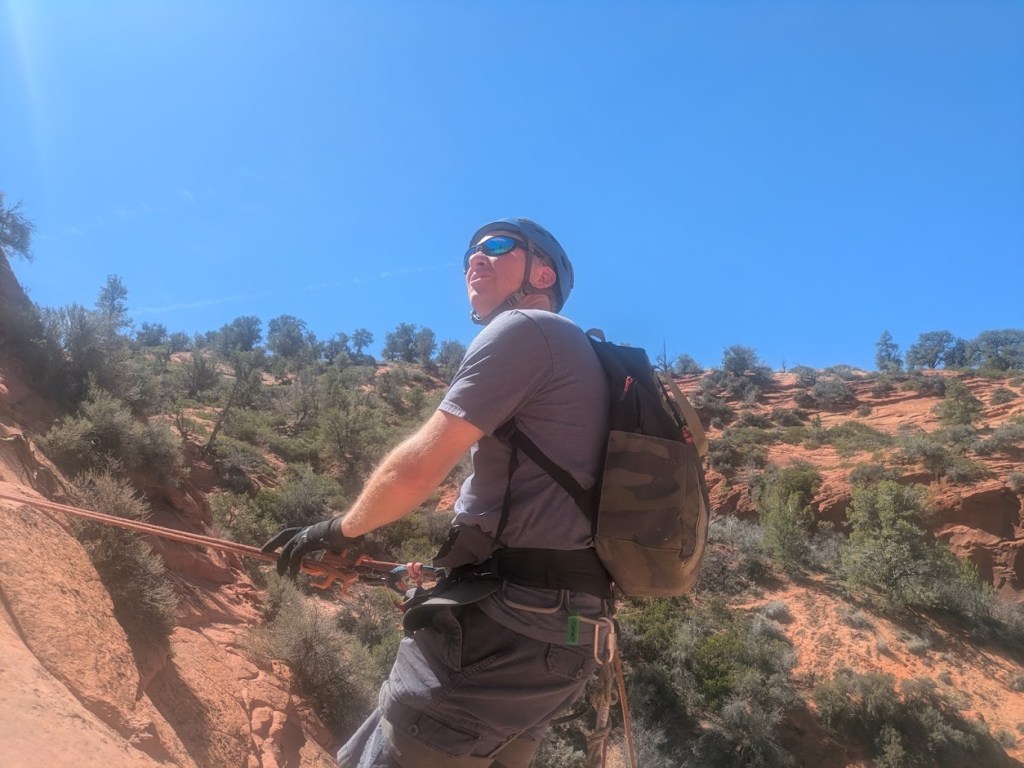 Canyoneers rappelling through the narrow sandstone walls of Diana’s Throne slot canyon in southern Utah near Zion National Park.